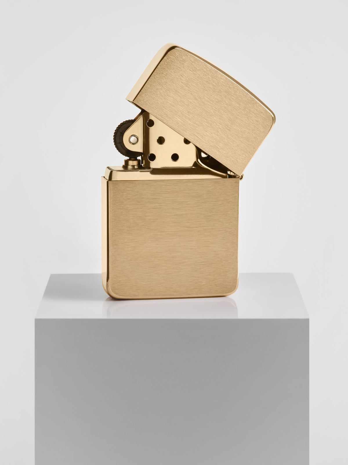 Zippo lighter in brushed brass finish with top open 